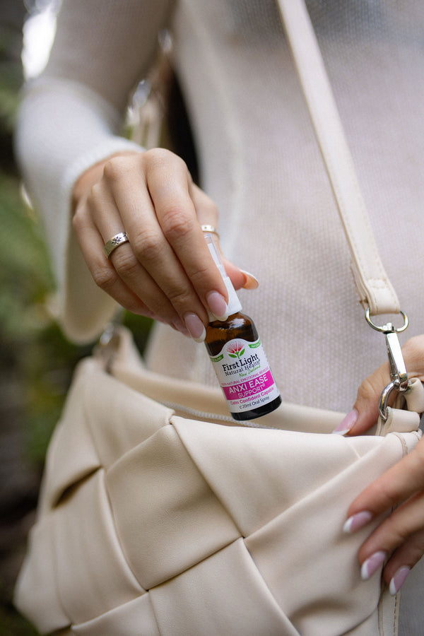 Anxi Ease Support oral spray being taken from a cream handbag
