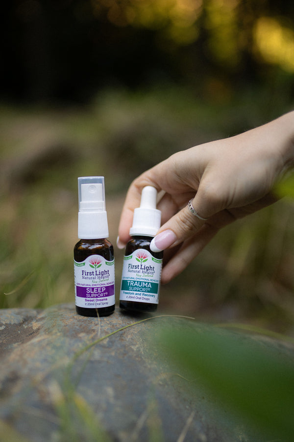 Sleep Support oral spray and Trauma Support oral drops on a forest rock